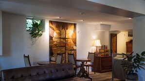 A modern living room with a leather sofa, a dining area with a table and chairs, and a kitchen area with cabinets and a countertop. - Kent Motel Niagara on the Lake (Niagara-on-the-Lake)