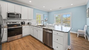 A modern kitchen with white cabinets, stainless steel appliances, and a marble countertop. - 1 Precious Memory - 4 Bed/3 Bath - Private Pool (North Myrtle Beach)