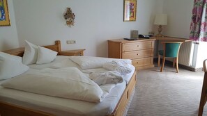 Ein Hotelzimmer mit Bett, Schreibtisch mit Stuhl, Lampe und Telefon.