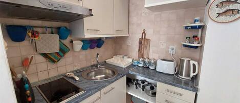 Kylskåp, spishäll, kaffe- och tebryggare och grytor/köksredskap