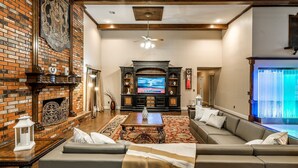 Ein Wohnzimmer mit Kamin, Fernseher und einer Couch.