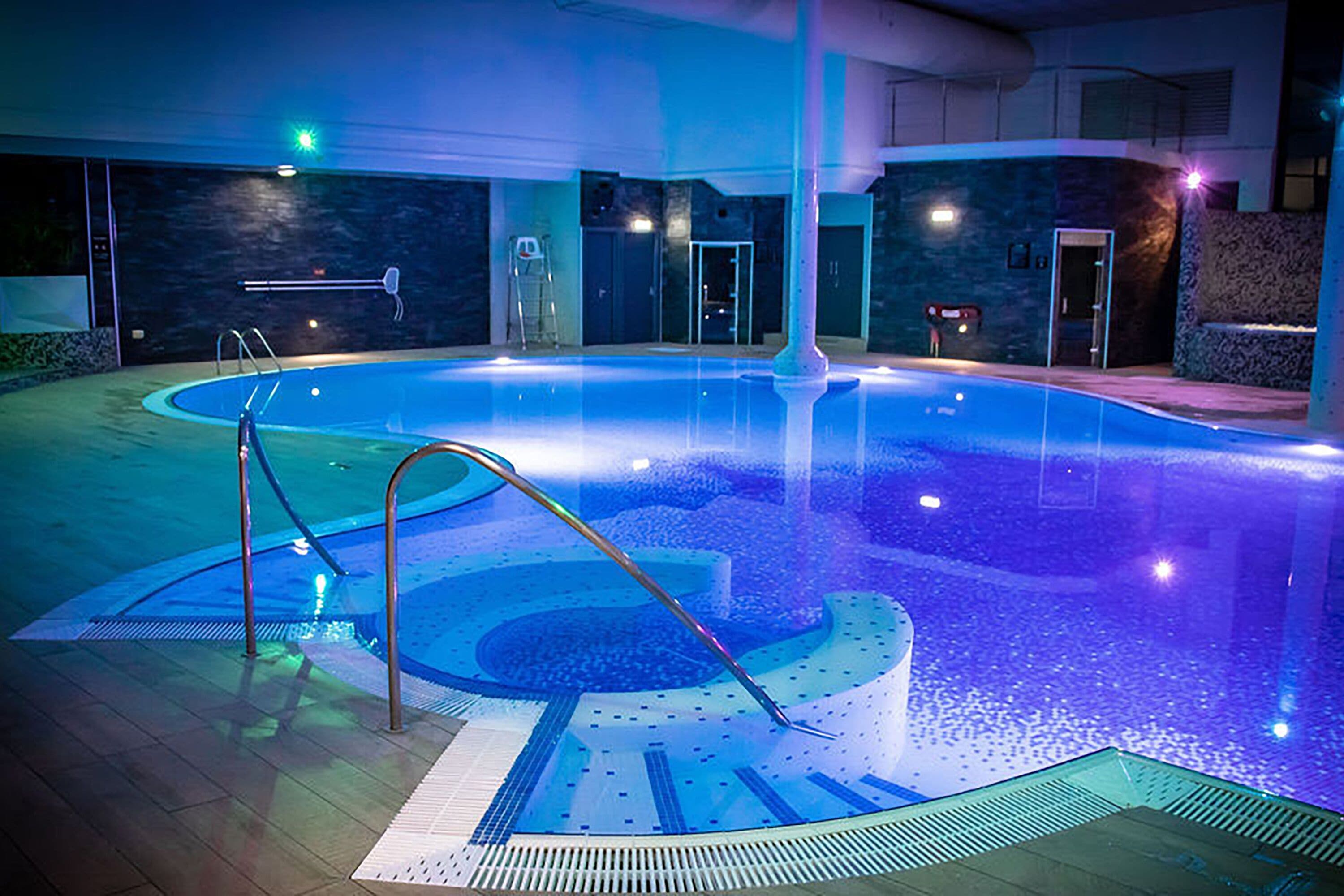 Una piscina cubierta, una piscina al aire libre