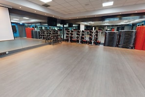 A spacious gym with weightlifting equipment and mirrors. - Village Hotel Nottingham (Nottingham)