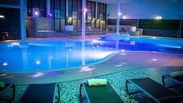 Piscina com espreguiçadeiras e área de spa.