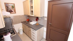 Una cocina compacta con estufa a gas, un lavamanos y armarios de madera.