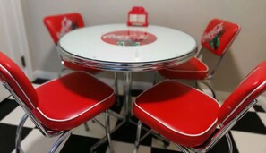 A round table with a white top and red chairs with a red logo. - Riversides Relaxing Retreat (Jacksonville)