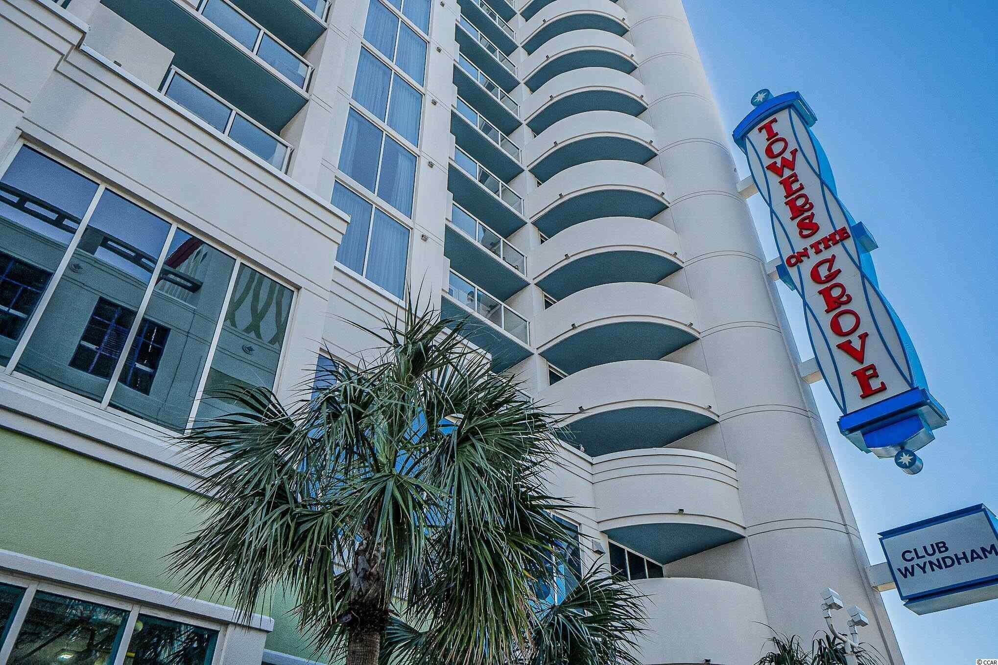 Un grand hôtel avec une enseigne indiquant « Towers at the Grove » et « Club Wyndham ».
