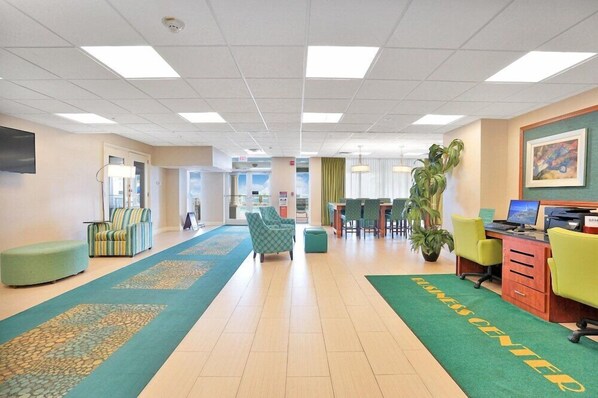 A hotel lobby with a reception desk, seating area, and a green carpet with 'HOTEL CENTER' text. - Hollywood Beach Tower (Hollywood)