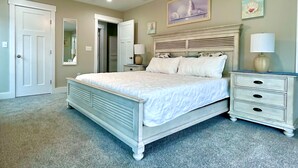 A bedroom with a bed, nightstands, a ceiling fan, and a door. - 484 E Market - New construction close to town and the Beach! (Lewes)