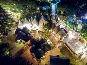 A resort with thatched-roof structures, a central courtyard, and outdoor seating areas. - Tenuta Monacelle (Monopoli)