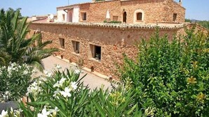 A stone building with multiple windows and a flat roof. - Finca Son Guardiola (Llucmajor)