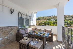 Enjoy dining or working in style with a wicker sofa and small table on this balcony.