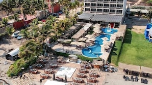 A resort with a swimming pool, outdoor seating, and a large building with solar panels. - Mishol Hotel And Beach Club (Acapulco)