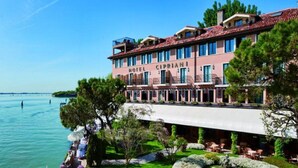 Ein Hotel mit Blick auf das Wasser, mehreren Balkonen und Außenbereichen zum Sitzen.