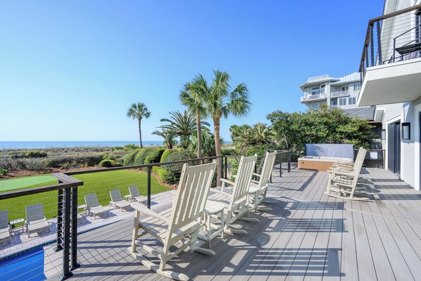 A deck with outdoor seating, a pool, and a view of the ocean. - Stunning oceanfront home offering private pool & hot tub, steps from Coligny! (Hilton Head)