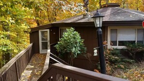 A wooden staircase leading to a house with a small porch, surrounded by autumn foliage. - Summer is here, cool down on Beech mountain! (Beech Mountain)