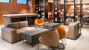 A modern lounge area with a bar, seating arrangements, and a bookshelf. - Comfort Hotel ERA Kyoto Horikawagojo (Kyoto)