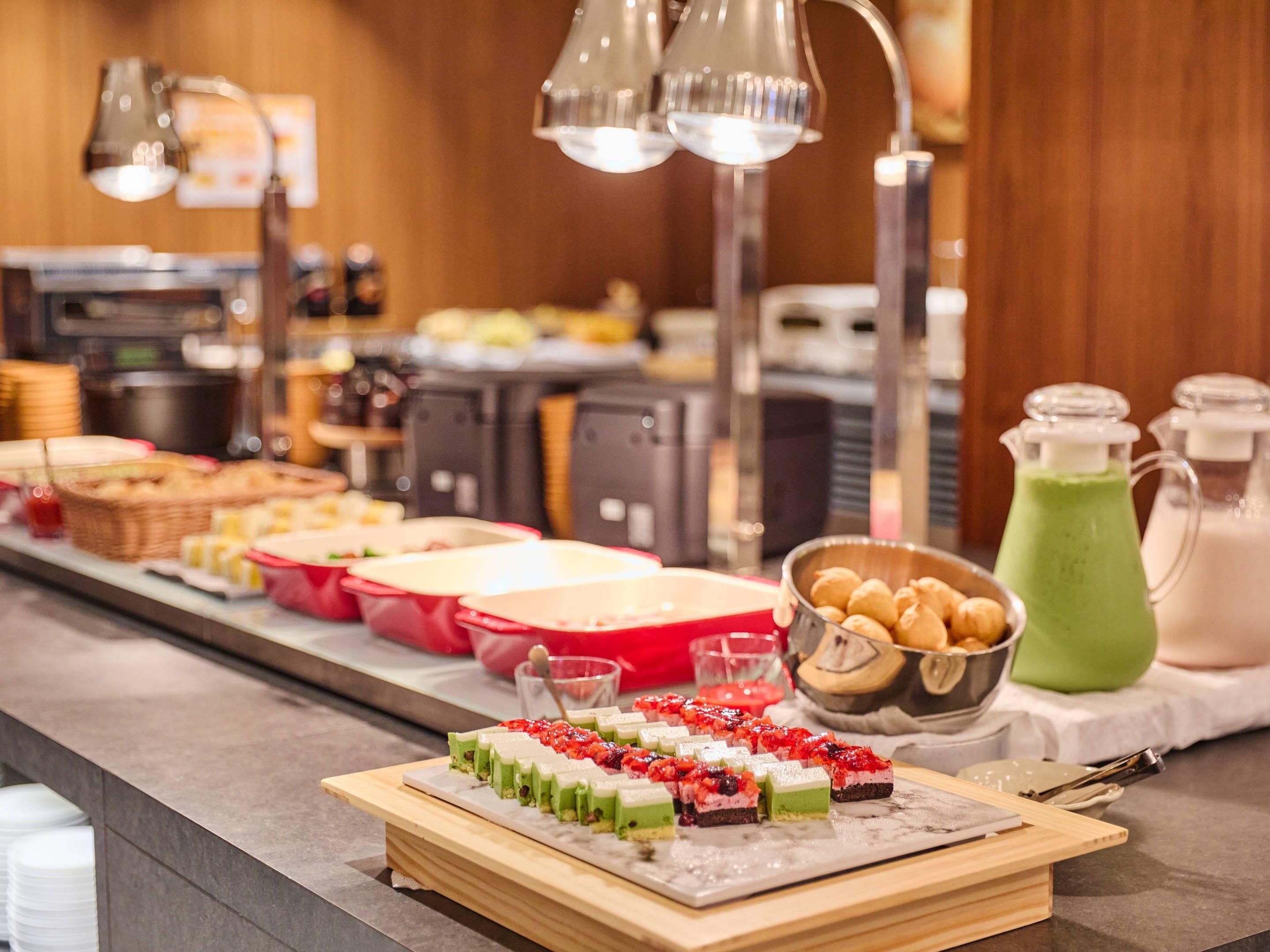 Buffet com diversos tipos de comida e uma bebida verde.