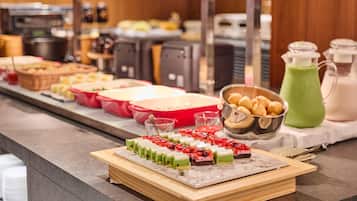 Buffet com diversos tipos de comida e uma bebida verde.