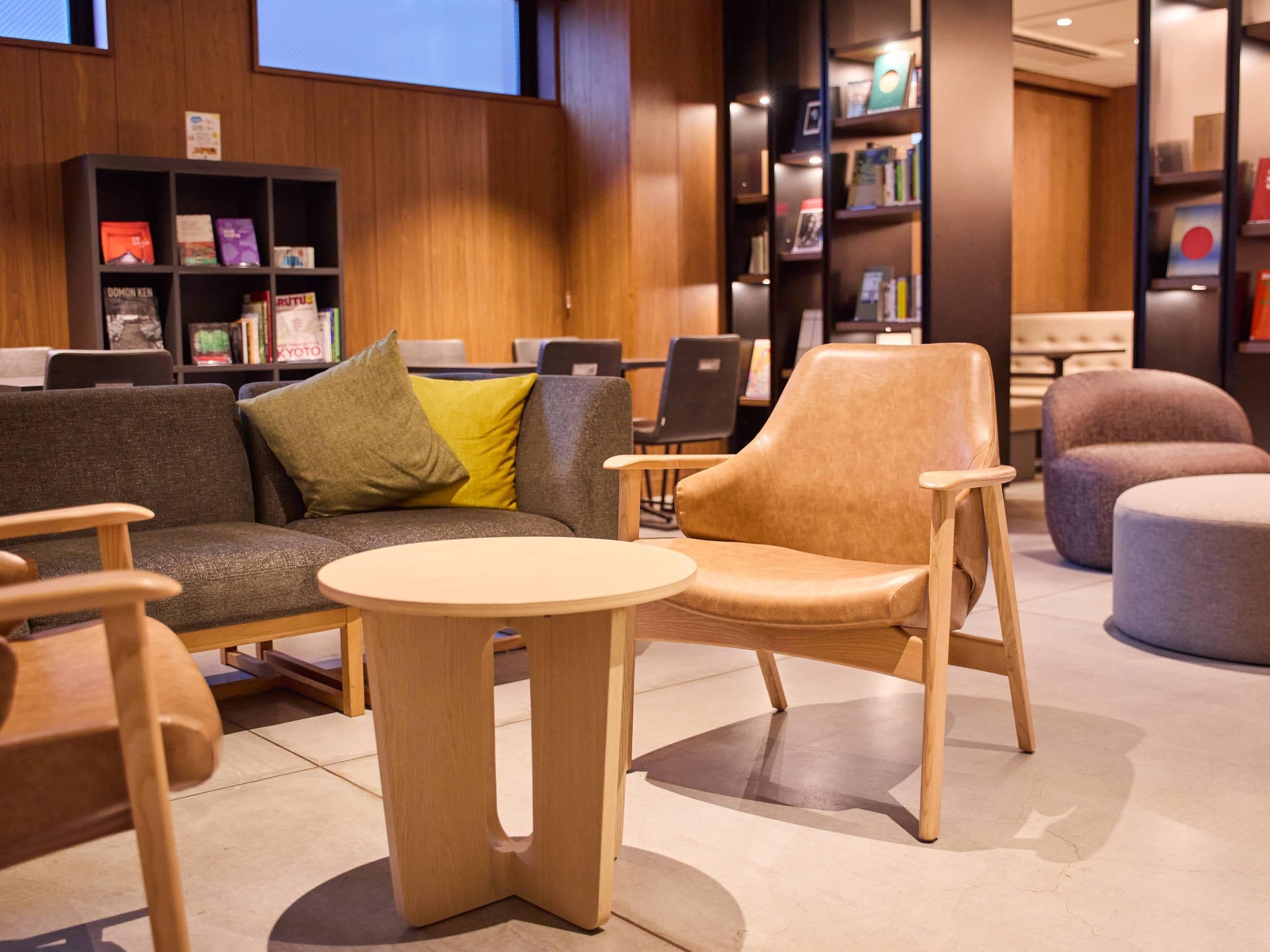A modern library with a sofa, chairs, and a round table.
