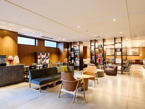 A modern lounge area with seating, a coffee station, and a bookshelf. - Comfort Hotel ERA Kyoto Horikawagojo (Kyoto)