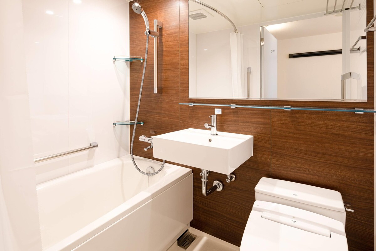 A modern bathroom with a bathtub, a sink, and a toilet.