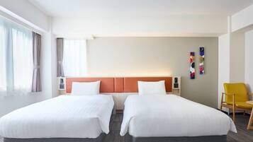 Quarto de hotel com duas camas, cabeceira, uma cadeira e uma parede com um quadro.