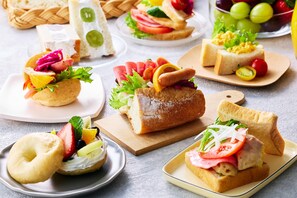 A variety of sandwiches and pastries on plates and a wooden board. - Comfort Hotel ERA Kyoto Horikawagojo (Kyoto)