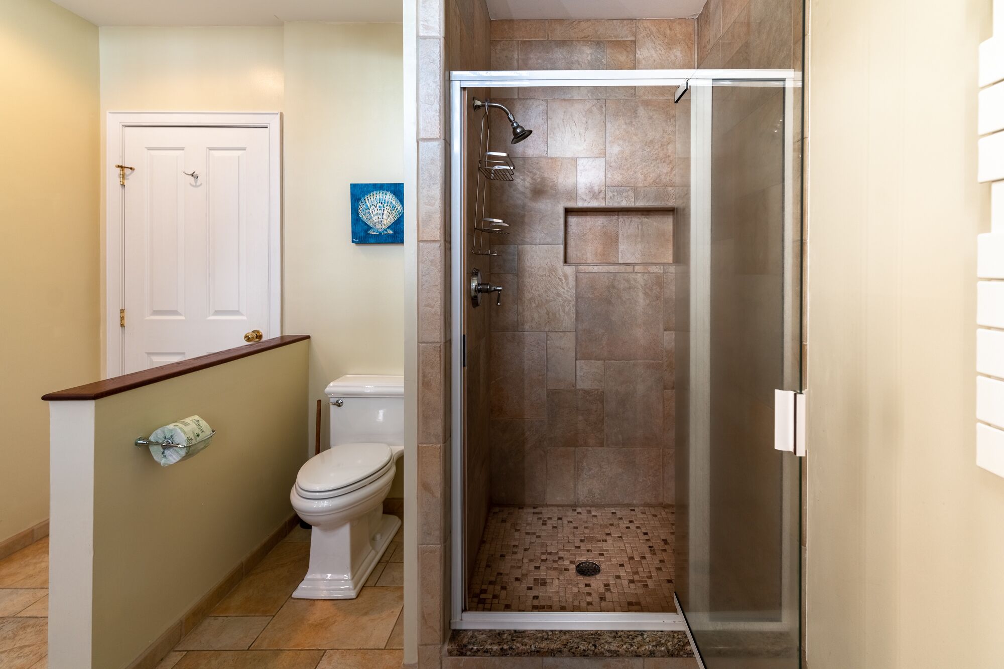 A bathroom with a toilet, shower, and a towel rack.