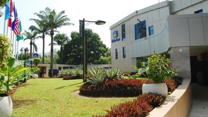 A hotel with a modern design, featuring a well-maintained lawn and various plants. - Best Western Starfire Hotel (Lagos)