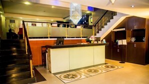 A modern kitchen with a central island, a staircase, and a chandelier. - Best Western Starfire Hotel (Lagos)