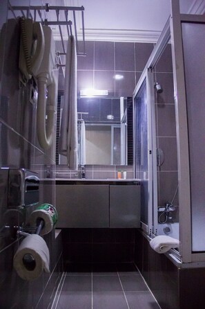 A compact bathroom with a sink, mirror, and shower. - Best Western Starfire Hotel (Lagos)