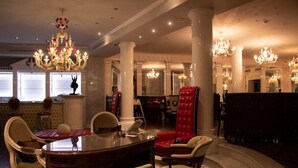 A luxurious dining area with a round table, multiple chairs, and ornate chandeliers. - Villa Palma Boutique Hotel (Panama City)