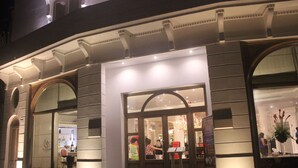 A hotel entrance with a grand archway, large windows, and a well-lit facade. - Villa Palma Boutique Hotel (Panama City)