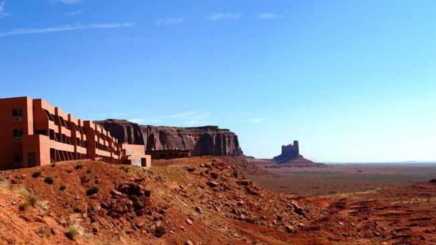 A desert landscape with a building and rock formations. - The View Hotel (Oljato-Monument Valley)