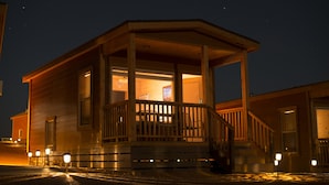 A wooden cabin with a porch, a staircase, and a window. - The View Hotel (Oljato-Monument Valley)