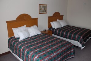 Two single beds with wooden headboards, a small bedside table, and a framed picture on the wall. - The View Hotel (Oljato-Monument Valley)