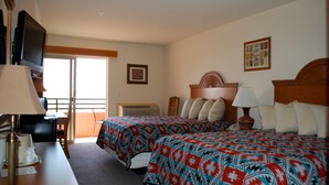 A hotel room with two beds, a desk, a television, and a window with a view. - The View Hotel (Oljato-Monument Valley)