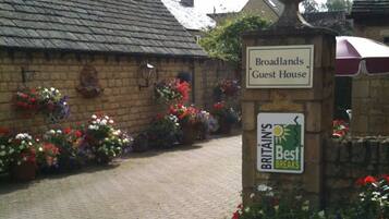 Una casa de huéspedes llamada 'Broadlands' con un letrero que indica que forma parte de 'Britain's Best Breaks'.