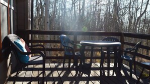 A wooden deck with a table and chairs, overlooking a forest. - 30 miles from Breck!! Avoid I70 traffic. (Fairplay)