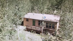 A small cabin with a green door, a satellite dish, and a wooden deck. - 30 miles from Breck!! Avoid I70 traffic. (Fairplay)