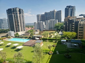 Ett bostadskomplex med flera höga byggnader, en swimmingpool och ett välskött trädgårdsområde.