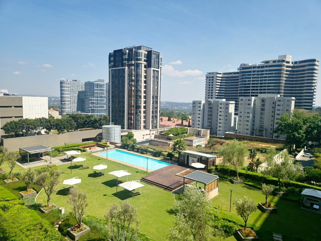 Un complexe résidentiel doté d’une piscine, de pelouses verdoyantes et de bâtiments modernes.