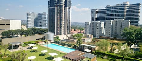 Un complejo residencial con piscina, césped y edificios modernos.