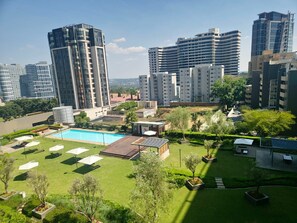 Zona residencial con piscina, sillas de descanso y un pequeño pabellón.
