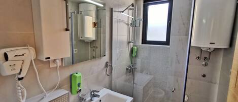 Tina con regadera, secadora de cabello, shampoo, papel de baño