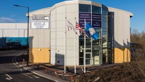 A modern building with a sign indicating it is Doncaster International, featuring amenities like air-conditioned bedrooms, a restaurant, bar, conference center, free parking, and free Wi-Fi. - Park Inn by Radisson Doncaster (Doncaster)