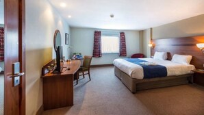 A hotel room with a bed, a desk, a chair, a mirror, and a window with curtains. - Park Inn by Radisson Doncaster (Doncaster)