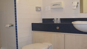 A bathroom with a white toilet, a sink with a dark countertop, and a mirror above the sink. - Park Inn by Radisson Doncaster (Doncaster)
