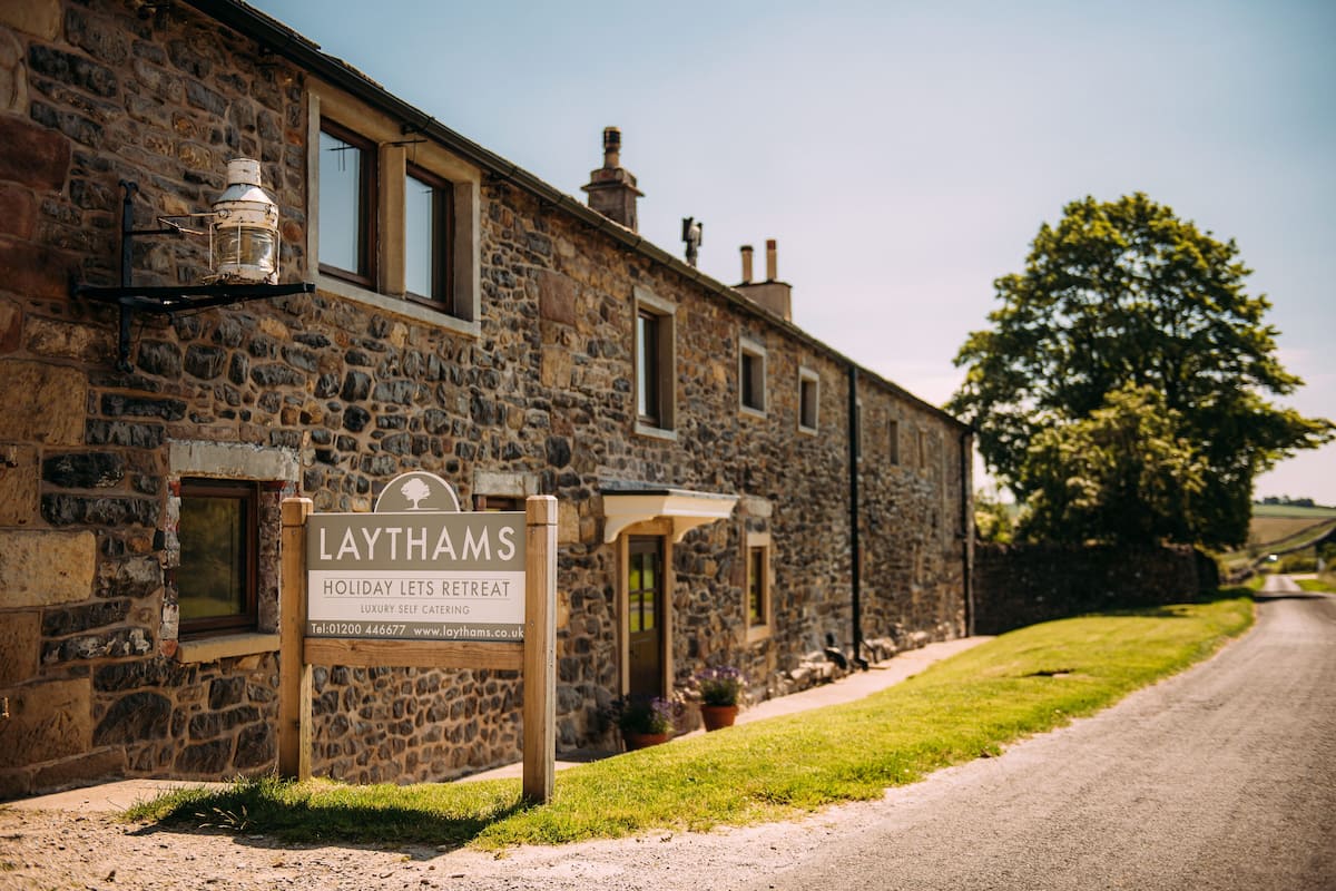A stone building with a sign for Laythams Holiday Lets Retreat.